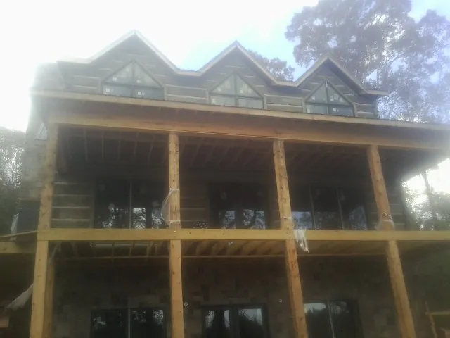 Dormers and porch framing on a large log home under construction — Roof Coating work by our crew in Wahkiacus
