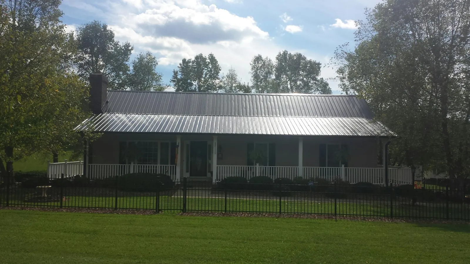 Gray metal roof on a brick ranch with a full width front porch — Gutter Guard Installation work by our crew in Wahkiacus