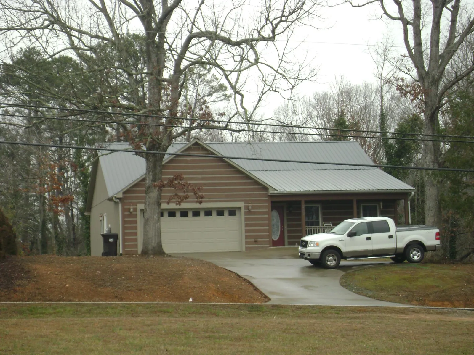 Gray metal roof on a log sided house with an attached two car garage in Wahkiacus