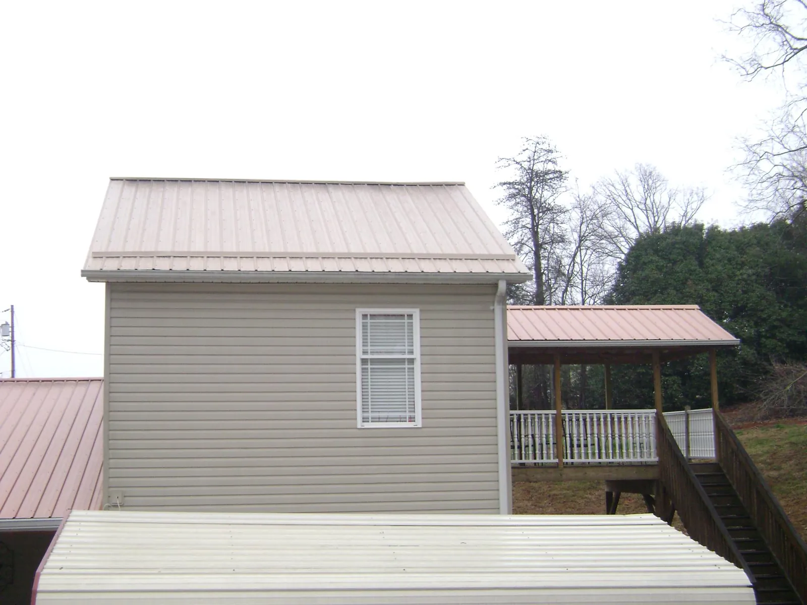 Tan metal roofs on a two story addition and attached porch, from a Roof Replacement job in Wahkiacus